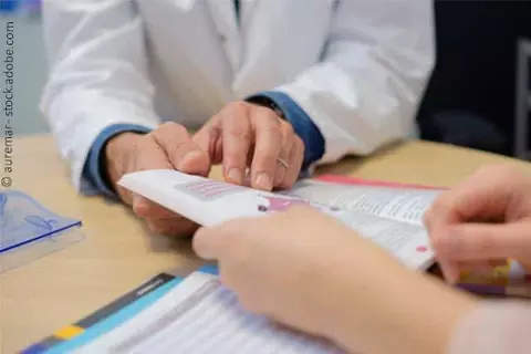 Arzt und Patient lesen Broschüre