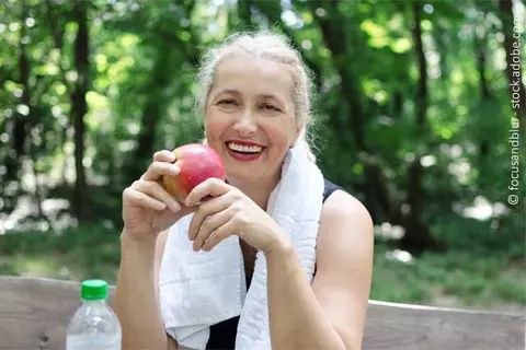Frau isst Apfel
