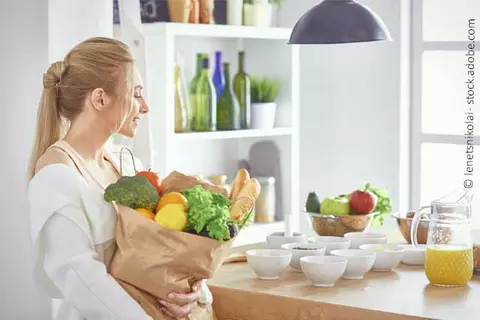 Frau mit Einkaufstüte in Küche