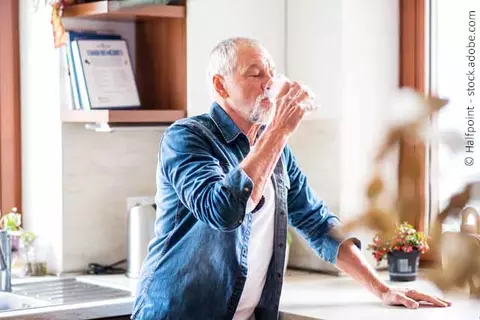Mann beim Trinken in Küche