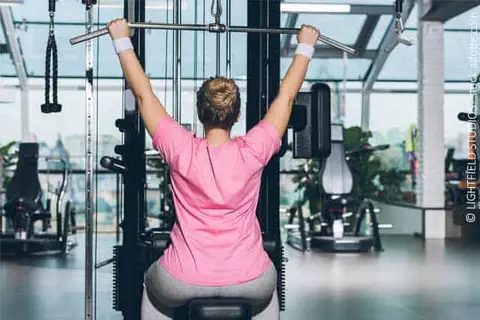 Frau beim Krafttraining im Fitnessstudio