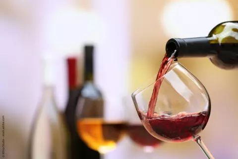 Wein wird in Weinglas gegossen