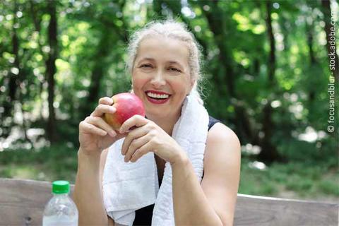 Frau isst Apfel