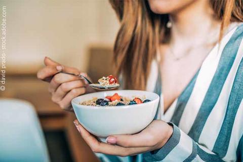 Frau isst Müsli mit Obst