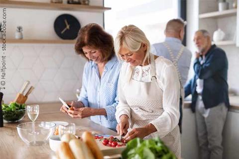 Frauen und Männer beim Kochen in Küche