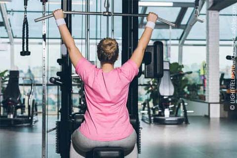 Frau beim Krafttraining im Fitnessstudio