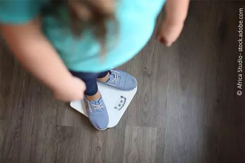 Kind mit Fettleber auf Waage