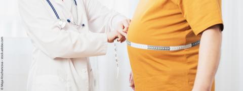 Arzt misst Taillenumfang eines Mannes